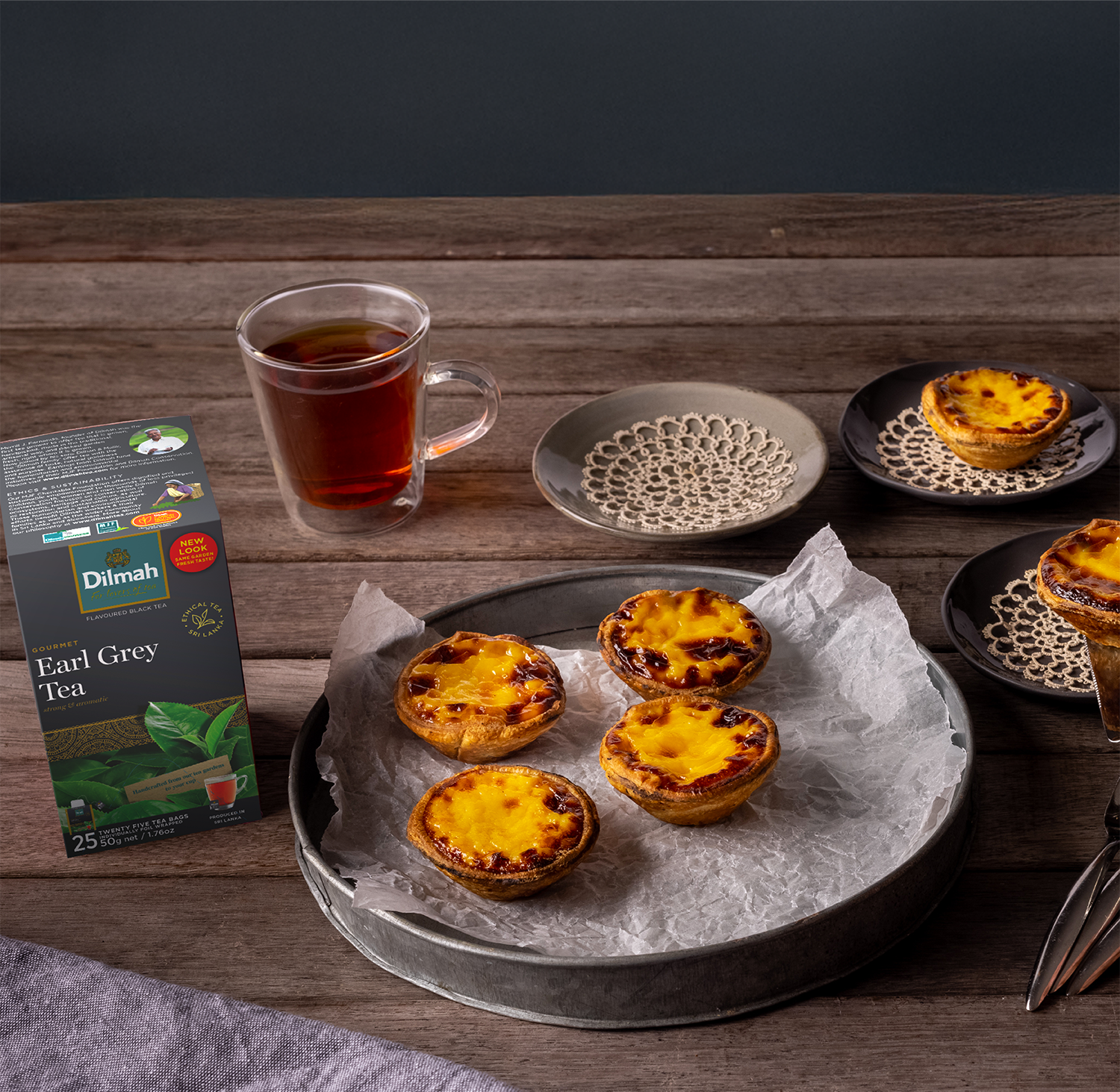 Herbata Dilmah Earl Grey obok tacy z babeczkami z kremem cytrynowym.