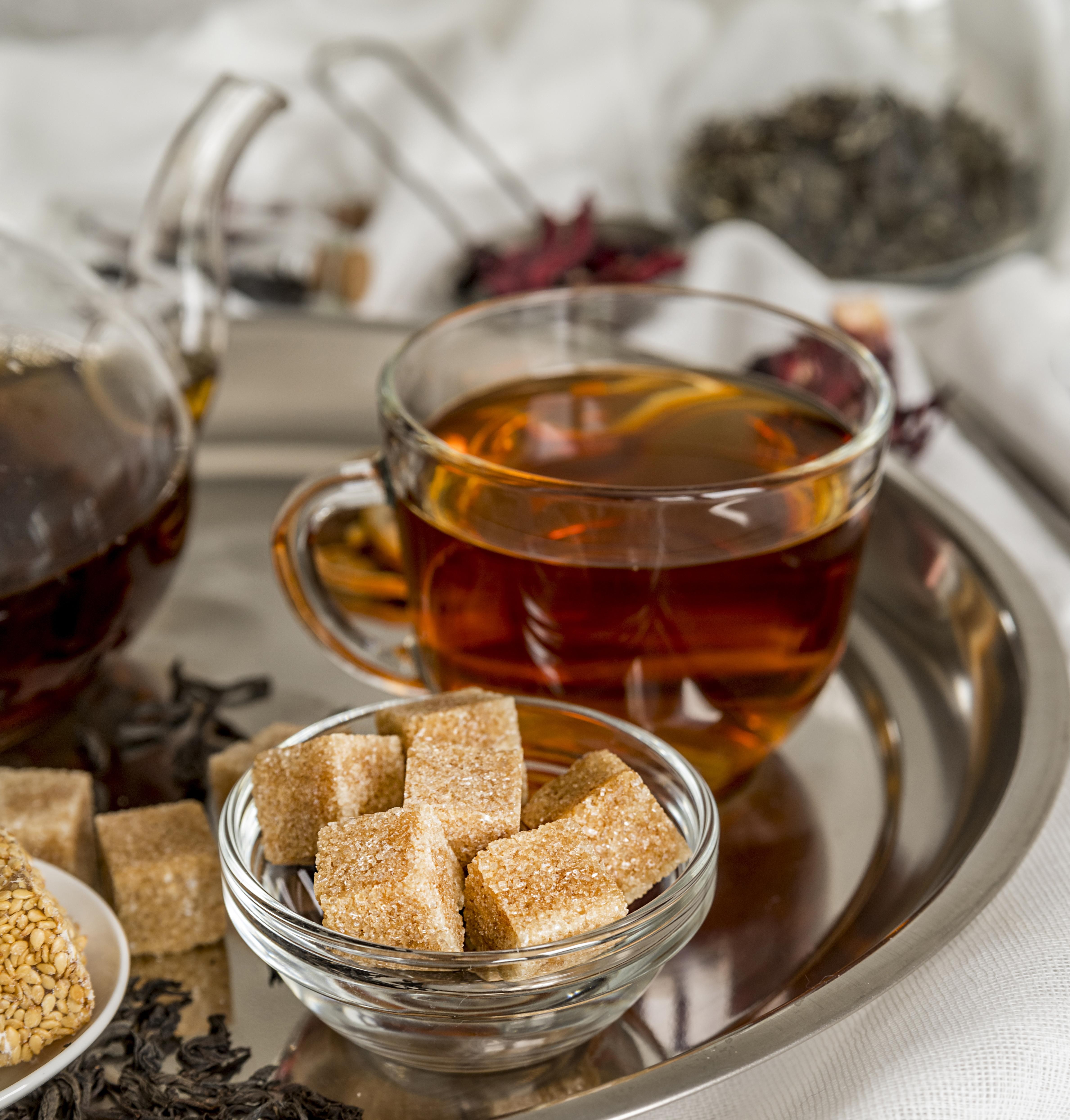 Świeżo zaparzona herbata Dilmah Earl Grey na tacy obok kostek brązowego cukru.