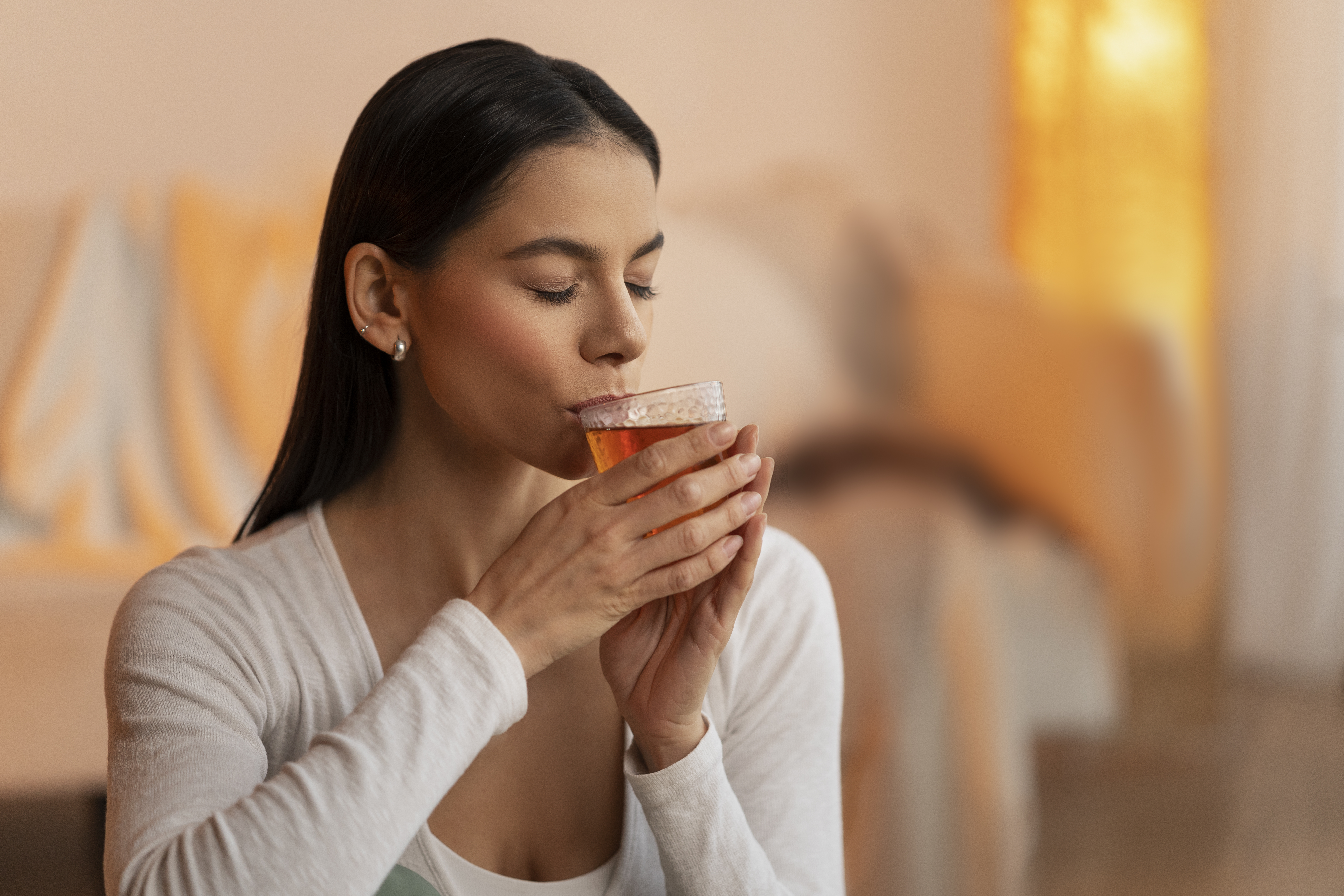 Kobieta relaksuje się w domowym zaciszu, pijąc herbatę Dilmah Earl Grey.