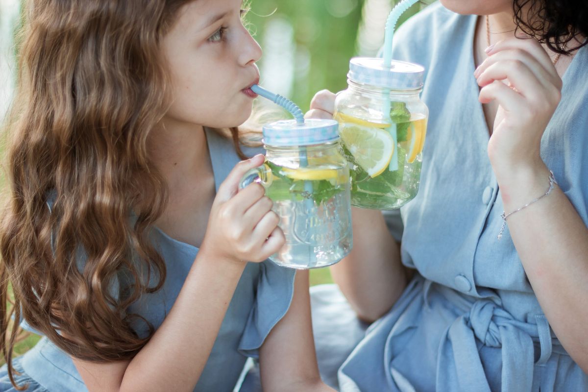 Mama i córka piją klasyczną lemoniadę cytrynowa z dodatkiem mięty.