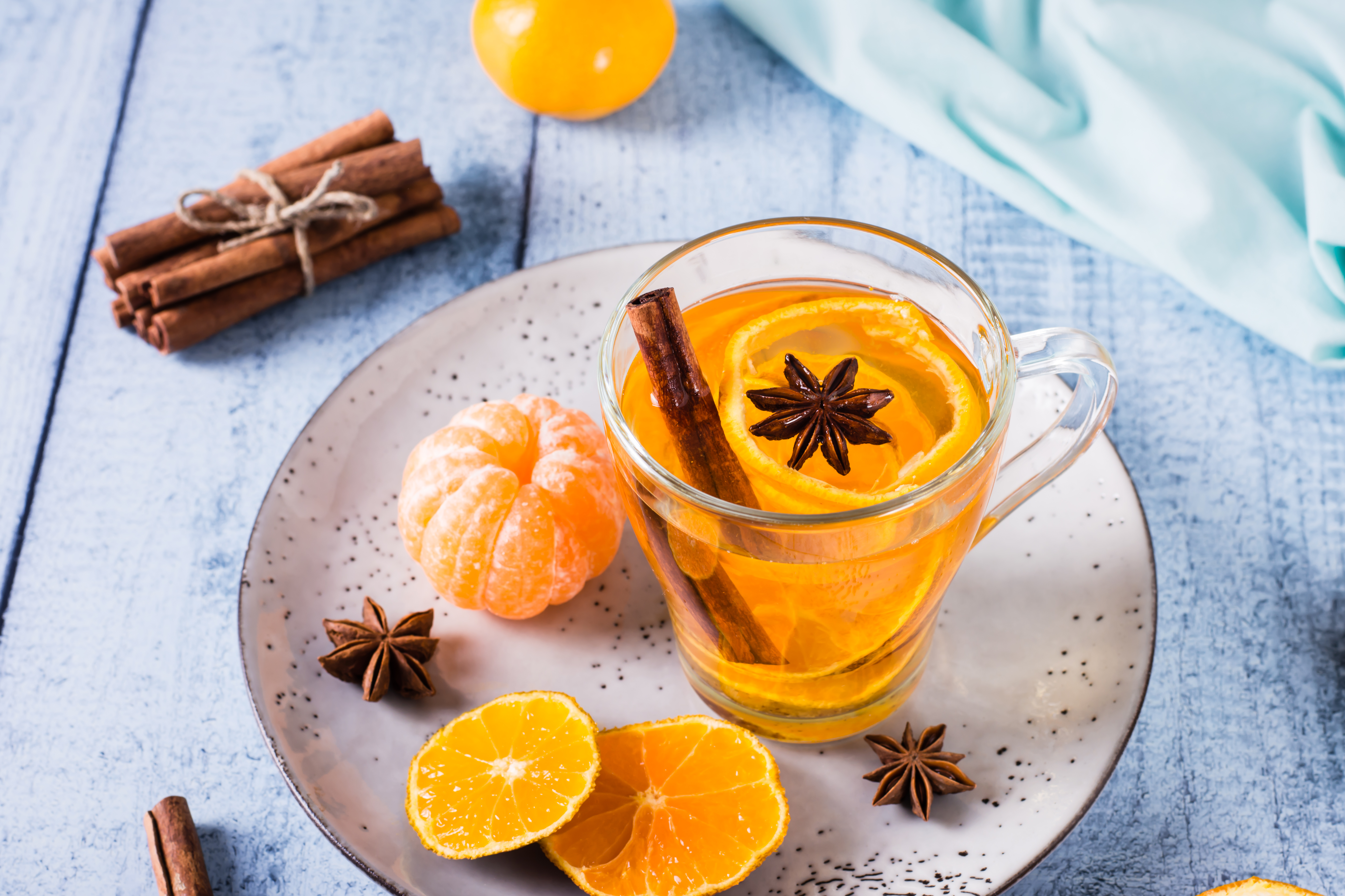 Jesienna herbata z mandarynką i pomarańczą, udekorowana skórką z mandarynki i cynamonem.